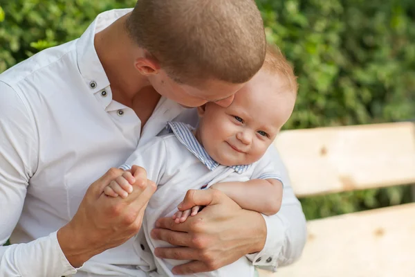 Joven feliz sosteniendo a un bebé sonriente de 7-9 meses —  Fotos de Stock