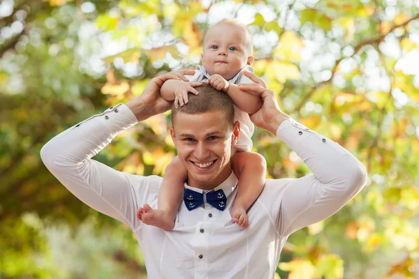 Happy young man holding a smiling 7-9 months old baby — Stock Photo, Image