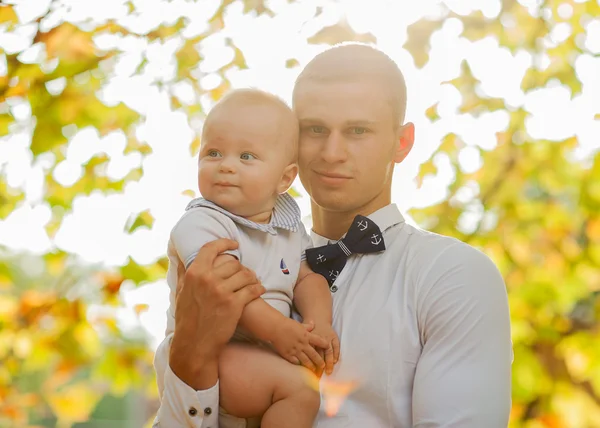 Glad ung man innehar en leende 7-9 månader gammal baby — Stockfoto