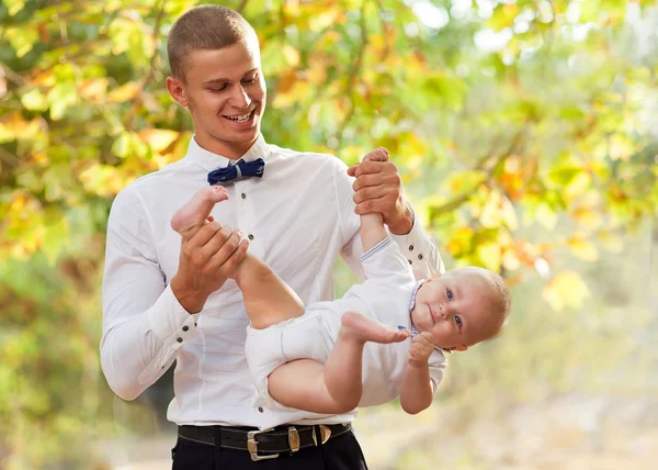 Gülümseyen bir 7-9 aylık bebek tutan mutlu bir genç adam — Stok fotoğraf