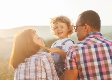 Mutlu aile dışarıda eğleniyor ve gülümsüyor.