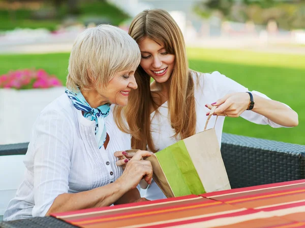 Vuxen mor och dotter funderar köpa efter shopping. de sitter på ett kafé utanför. — Stockfoto