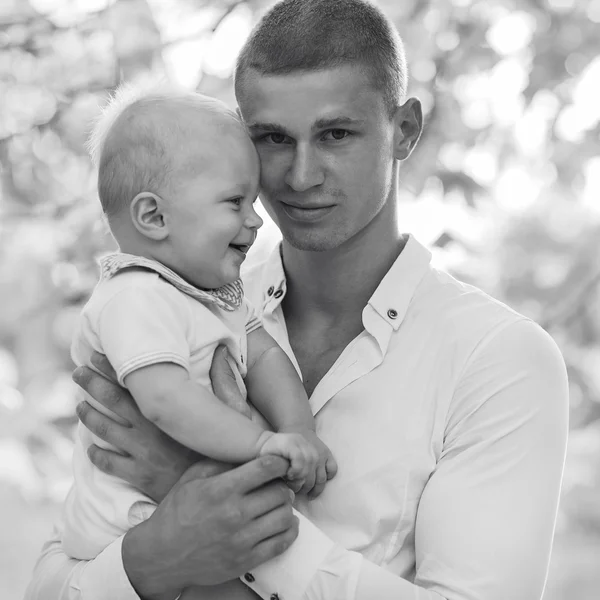 Happy young man holding a smiling 7-9 months old baby — Stock Photo, Image