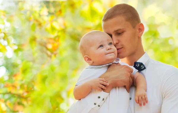 Joven feliz sosteniendo a un bebé sonriente de 7-9 meses — Foto de Stock