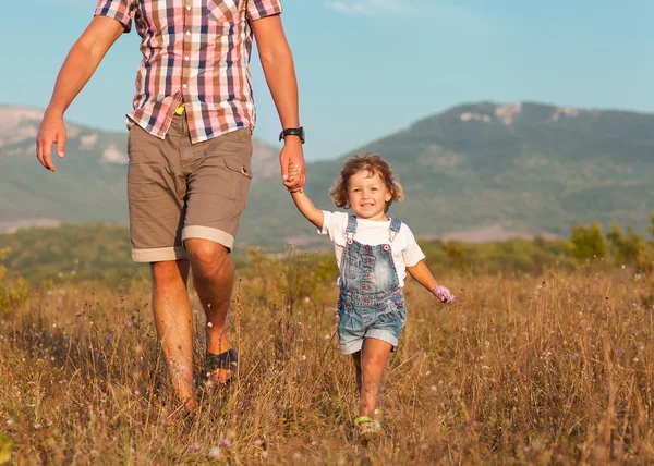 Vader en dochter lopen op het veld — Stockfoto