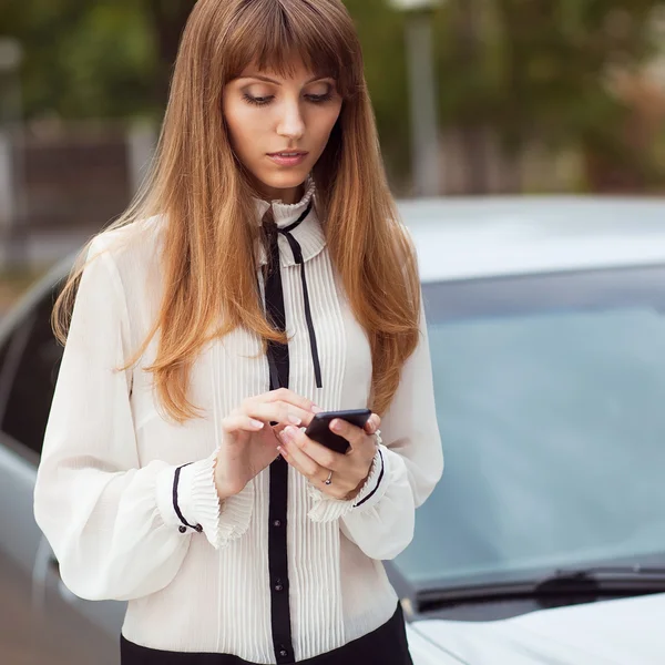 Unga vackra kvinnan skriver ett sms — Stockfoto