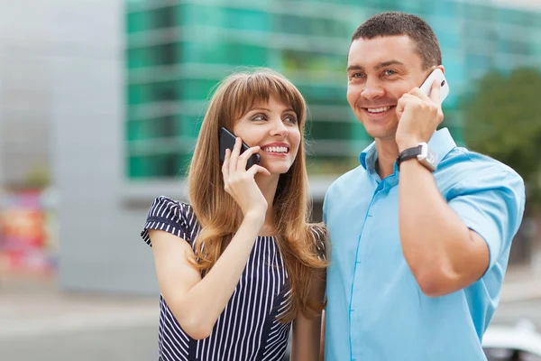 Stijlvol gekleed jonge paar praten over de telefoon. — Stockfoto