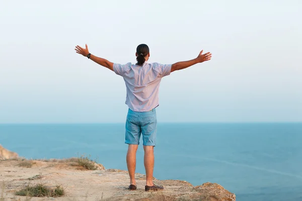 L'uomo in piedi su una roccia vicino al mare — Foto Stock