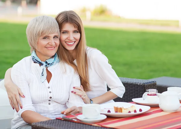 Adult mother and daughter drinking tea or coffee — Stock Photo, Image