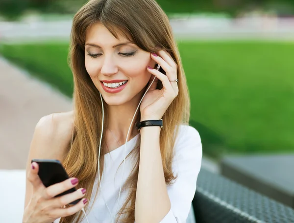 Young beautiful girl listening to MP3 player — Stock Photo, Image