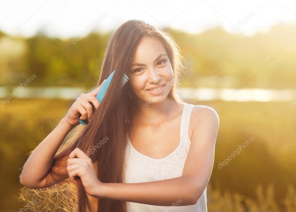 beautiful girl combs her hair Asian appearance