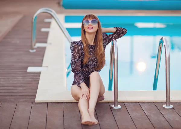 Mode meisje zit in de buurt van zwembaden — Stockfoto