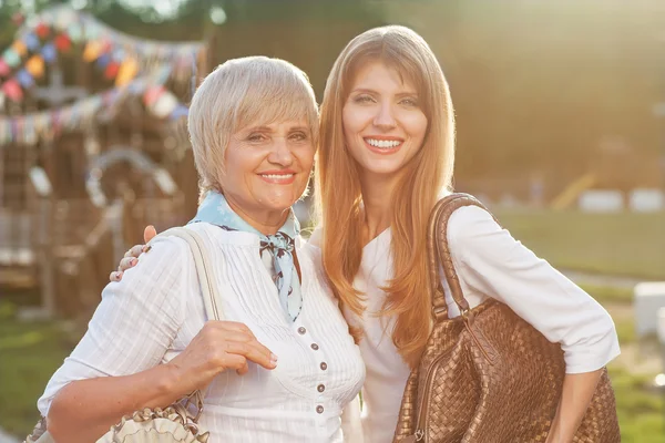 Mutter mit Tochter blickt im Garten in die Kamera — Stockfoto