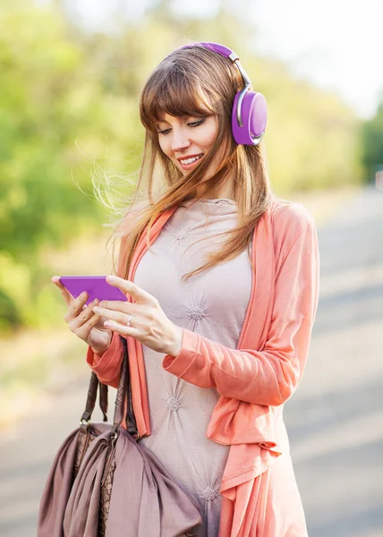 Jovem menina bonita ouvindo MP3 player na rua — Fotografia de Stock