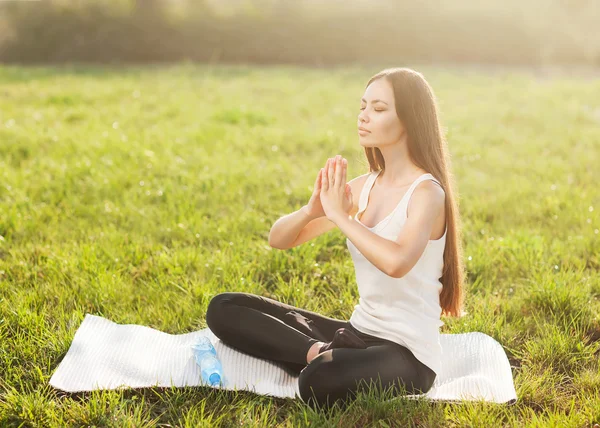 Mujer atractiva practica yoga en la naturaleza. Lotus Pose, ojos clos —  Fotos de Stock