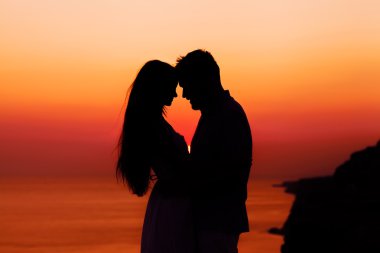 silhouette of a loving couple at sunset clipart