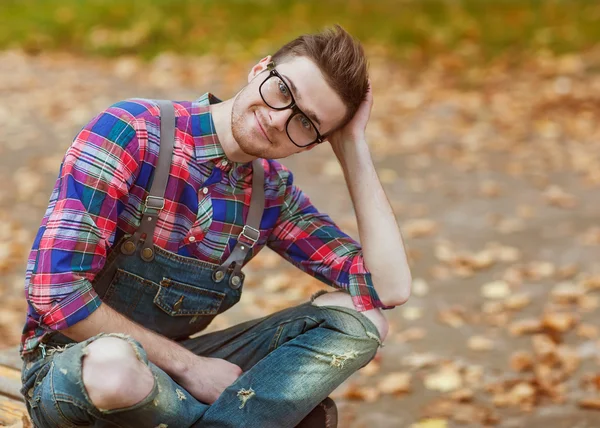 Hipster sitter i parken hösten — Stockfoto