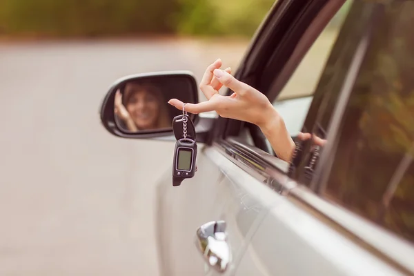 Menina alegre segurando chaves do carro da janela — Fotografia de Stock
