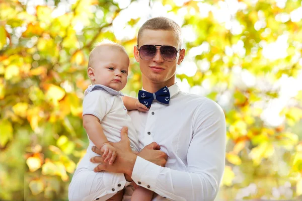 Felice giovane uomo che tiene un bambino sorridente di 7-9 mesi — Foto Stock