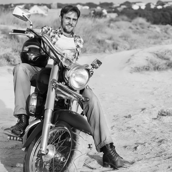 Motociclista homem senta-se em uma bicicleta — Fotografia de Stock