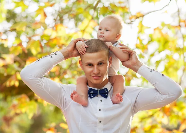 Happy young man holding a smiling 7-9 months old baby — Stock Photo, Image