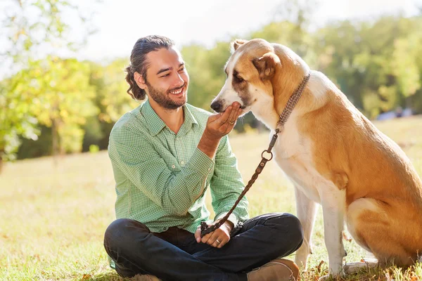 Man and shepherd walk in the park. — Stock Photo, Image