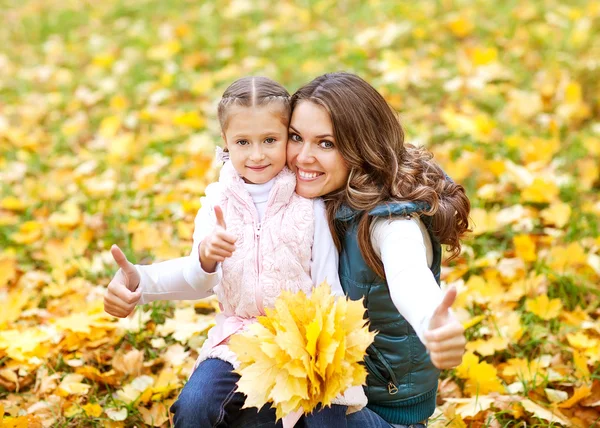 Mother and daughter playing in autumn park — Stock Photo, Image