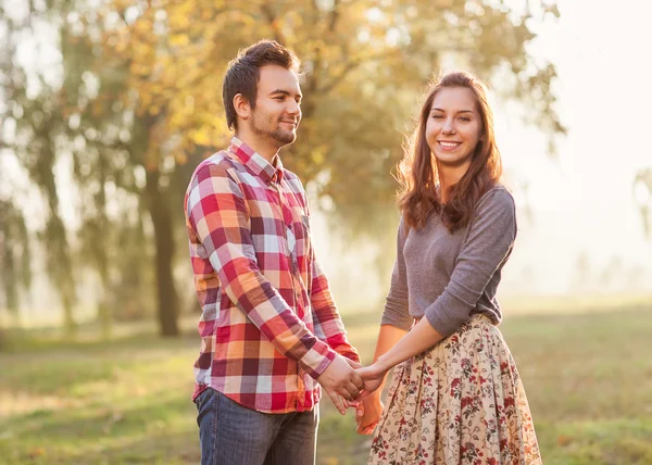 Young couple in love walking in the autumn park near the river. — Stock Photo, Image