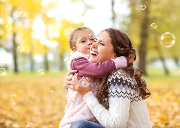 Мать и дочь веселятся в осеннем парке — стоковое фото
