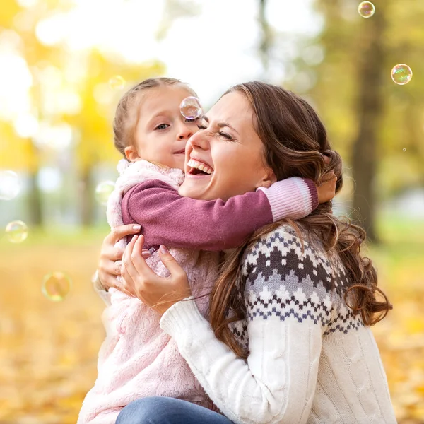 Matka i córka, zabawy w parku jesień — Zdjęcie stockowe