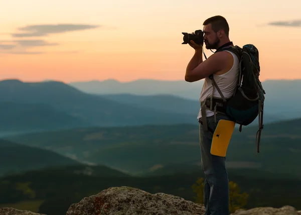 Młody człowiek z kamery profesjonalne fotografowanie krajobrazu — Zdjęcie stockowe