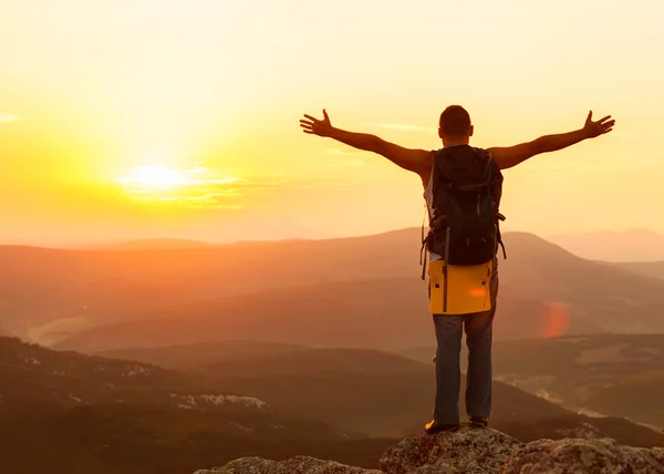 Guy in the mountains at sunset. the concept of freedom — Stock Photo, Image