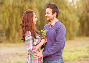 sonbahar parkta yürüyüş aşık genç bir çift Nehri yakınındaki.