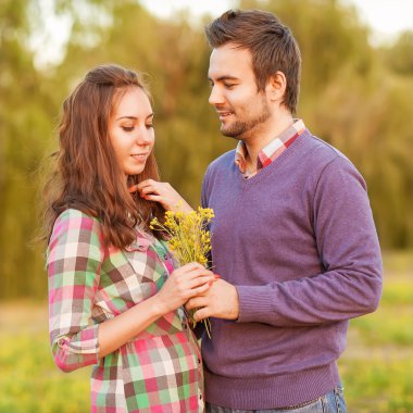 İki aşık, kır çiçekleri buketi kız çocuk verir