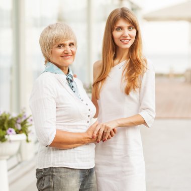 Yetişkin anne ve kızı büyük camdan ayakta