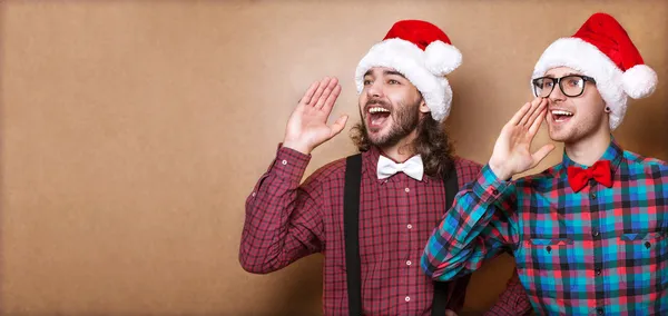 Zwei Jungs in Hipster-Klamotten von Weihnachtsmann in einem Weihnachtsgeschrei — Stockfoto