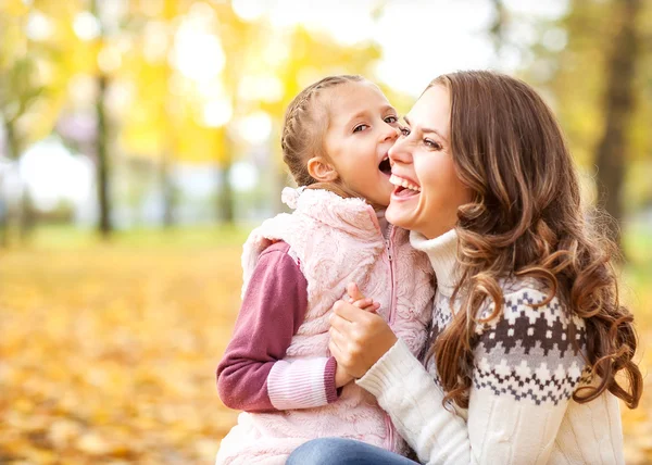 Joven madre y su niña se divierten en otoño — Foto de Stock