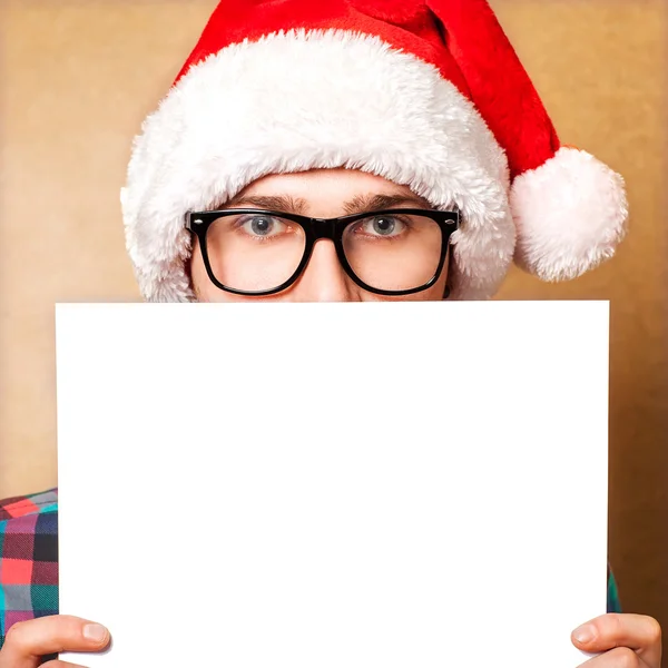 Weihnachtsmann zeigt lächelnd auf weißes Blanko-Schild — Stockfoto