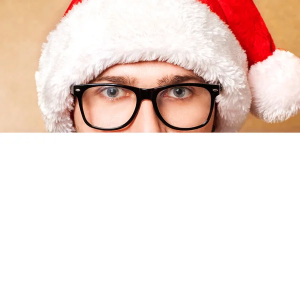 Weihnachtsmann zeigt lächelnd auf weißes Blanko-Schild — Stockfoto