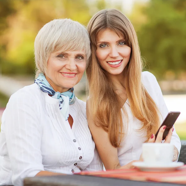 Adult mother and daughter drinking tea or coffee — Stock Photo, Image