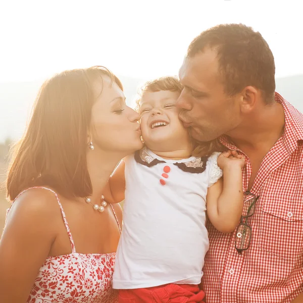 Счастливая мать, отец и дочь на закате — стоковое фото