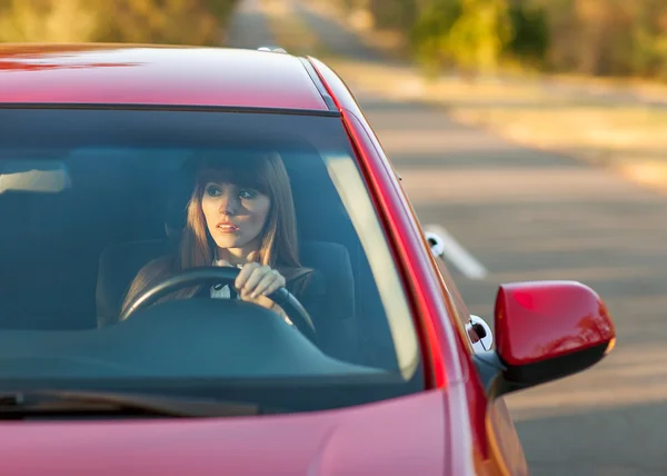 Jolie fille dans une voiture au coucher du soleil — Photo