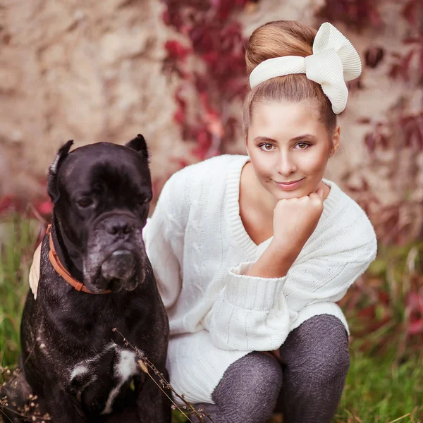 一个年轻的女孩，抱着一个大狗甘蔗的肖像 — 图库照片