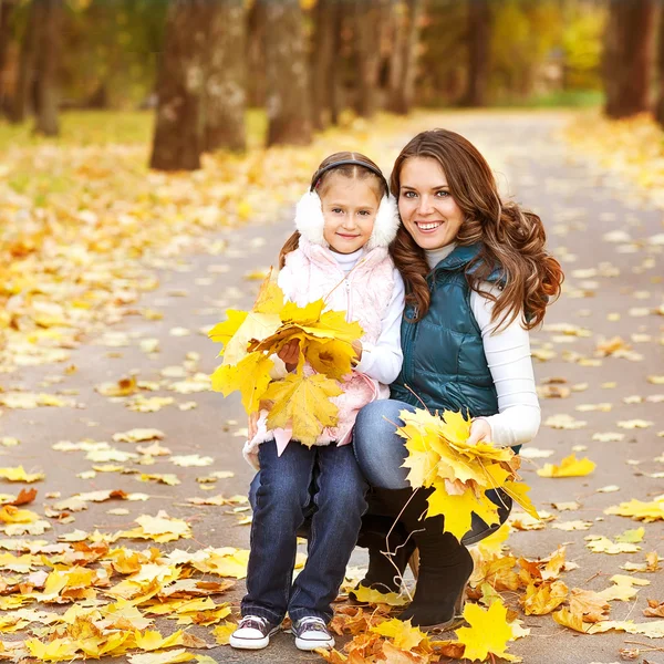 Madre e hija divirtiéndose en el parque de otoño entre el otoño —  Fotos de Stock