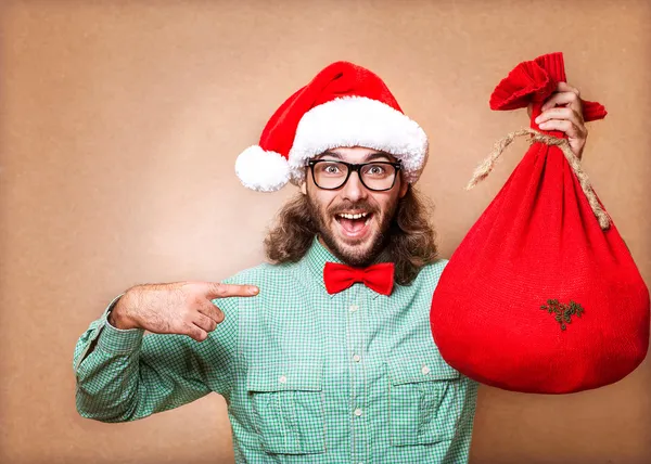 Hipster w santa claus ubrania z worka z prezentami — Zdjęcie stockowe