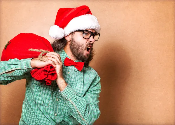 Hipster dans les vêtements du Père Noël avec des cadeaux — Photo