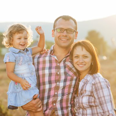 mutlu anne, baba ve kızı günbatımı