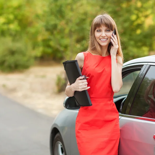 Iş kadını arabasının yanında duran telefonda konuşurken — Stok fotoğraf