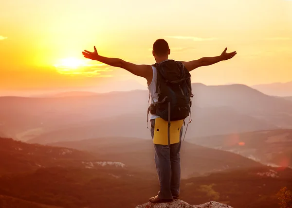 Guy in the mountains at sunset. the concept of freedom — Stock Photo, Image