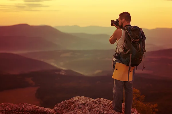 Photographe de nature prenant des photos dans les montagnes Image En Vente